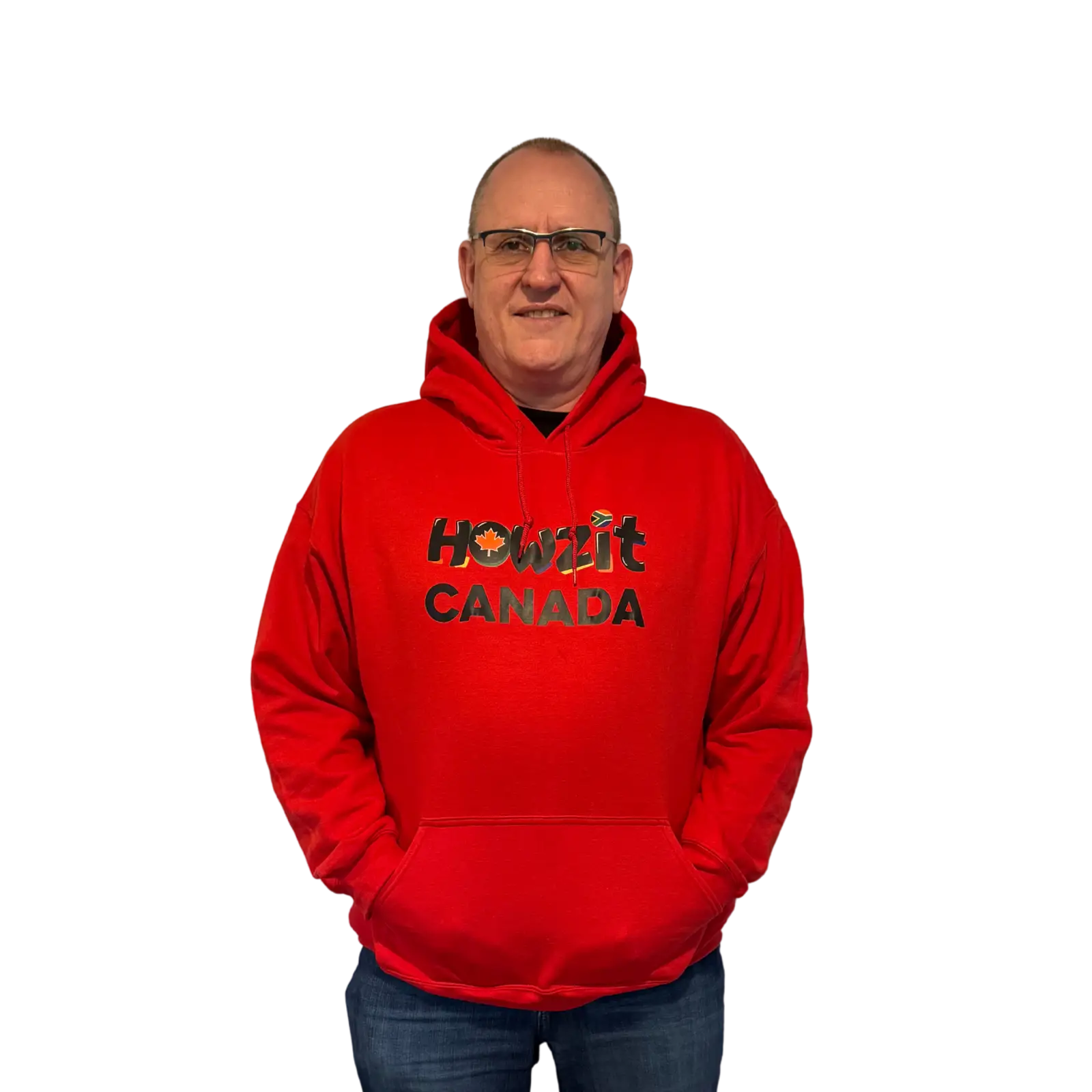 Man wearing a red Howzit Canada hoodie, smiling and standing with hands in pockets.