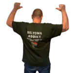ack view of a man wearing a black Biltong Addict T-shirt featuring bold white text and a South African flag heart design.