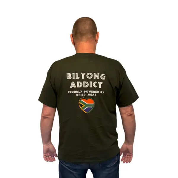 Back view of a man wearing a black Biltong Addict T-shirt featuring bold white text and a South African flag heart design.