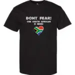 A black T-shirt featuring “Don’t Fear! The South African is Here!” text and a heart-shaped South African flag.