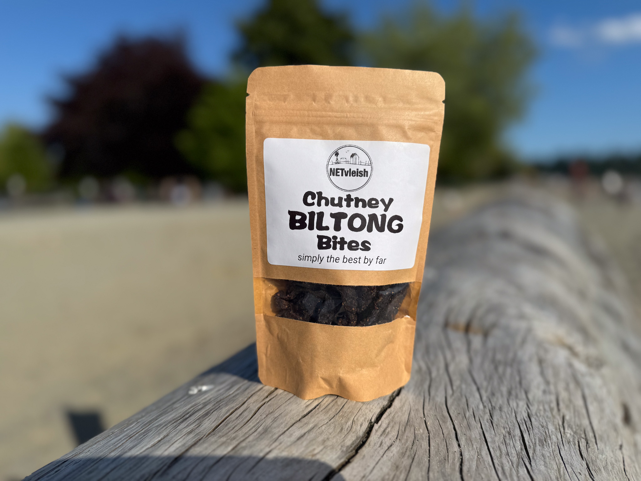 Chutney biltong bites snack pack photographed on a beach log in West Vancouver